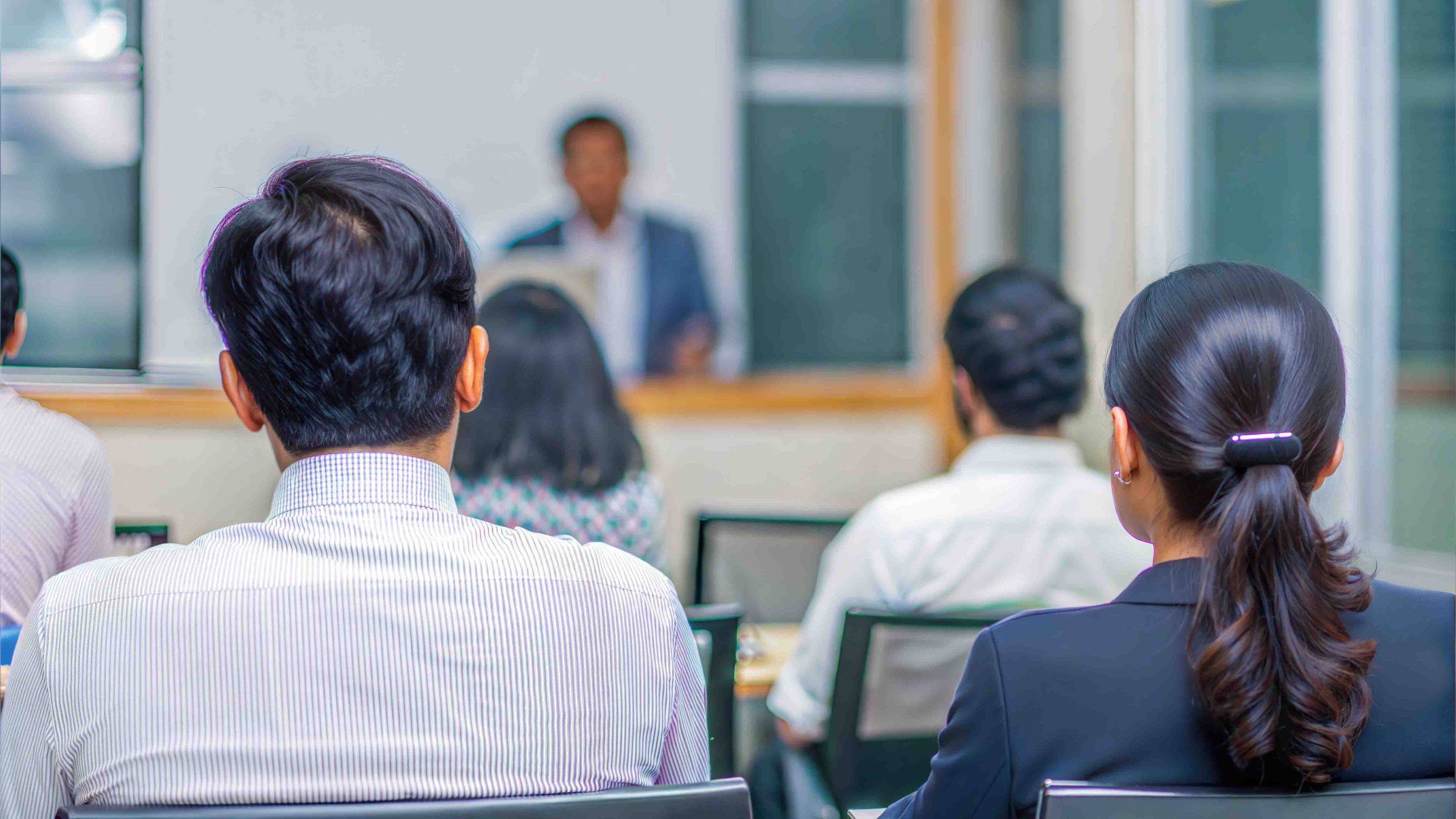 Corporate POSH training session with employees attentively listening to a speaker in a conference room